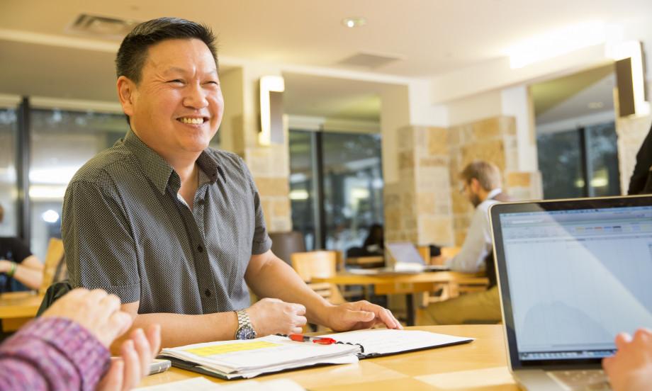 A graduate student studies with fellow students in Hedberg Library.